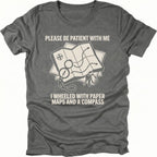 Grey T-Shirt with paper map and compass graphic reading “Please Be Patient With Me I Wheeled With Paper Maps And A Compass” shown on front view by Trail Snark.