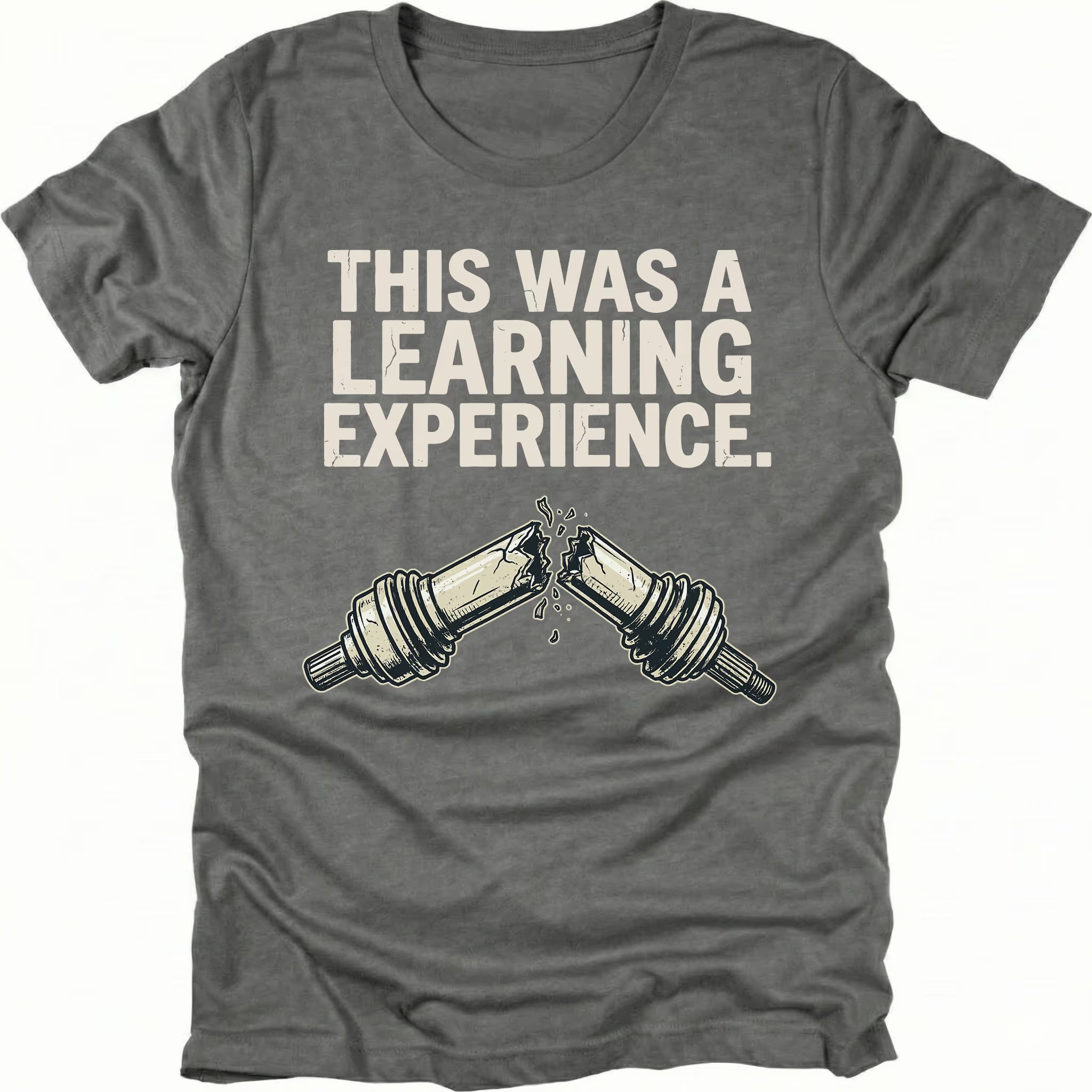 Grey t-shirt with text reading “This Was a Learning Experience” above an illustration of a broken axle or CV joint, shown on the front.