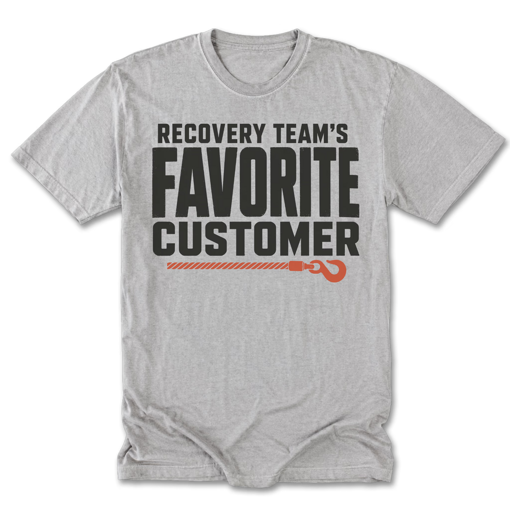 A light heather gray t-shirt with a graphic print that reads 'RECOVERY TEAM'S FAVORITE CUSTOMER' in black, accented by an orange rope and hook illustration, displayed on a clean white background.