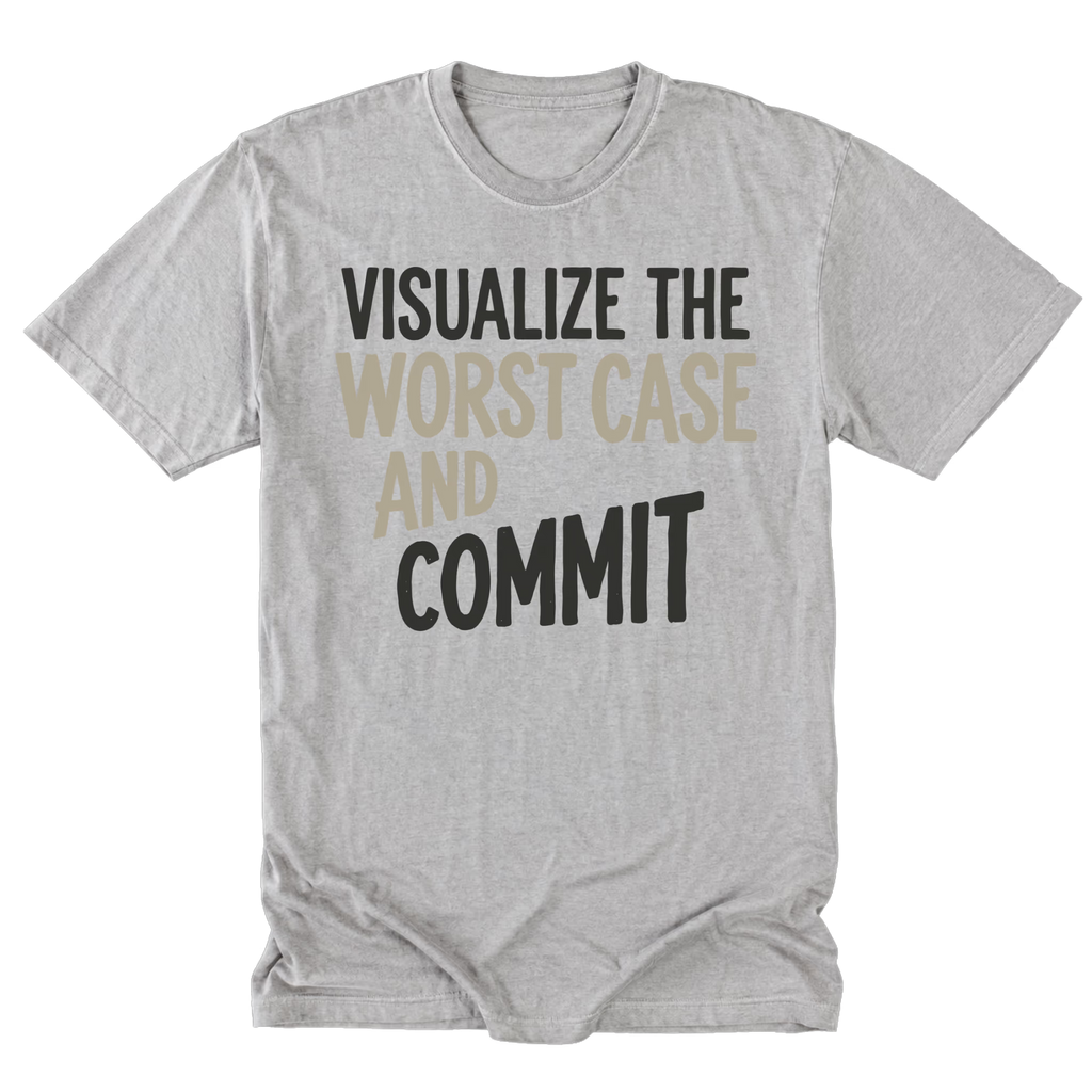 A light steel gray tall short-sleeve t-shirt with a graphic text print reading 'VISUALIZE THE WORST CASE AND COMMIT' in black and beige lettering, displayed flat against a white background.