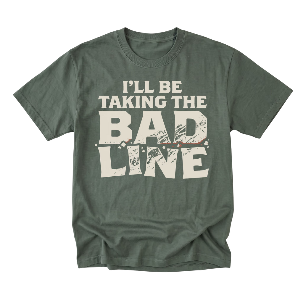 A military green short-sleeve t-shirt with a distressed cream-colored graphic text that reads 'I'LL BE TAKING THE BAD LINE' across the chest, displayed on a clean white background.