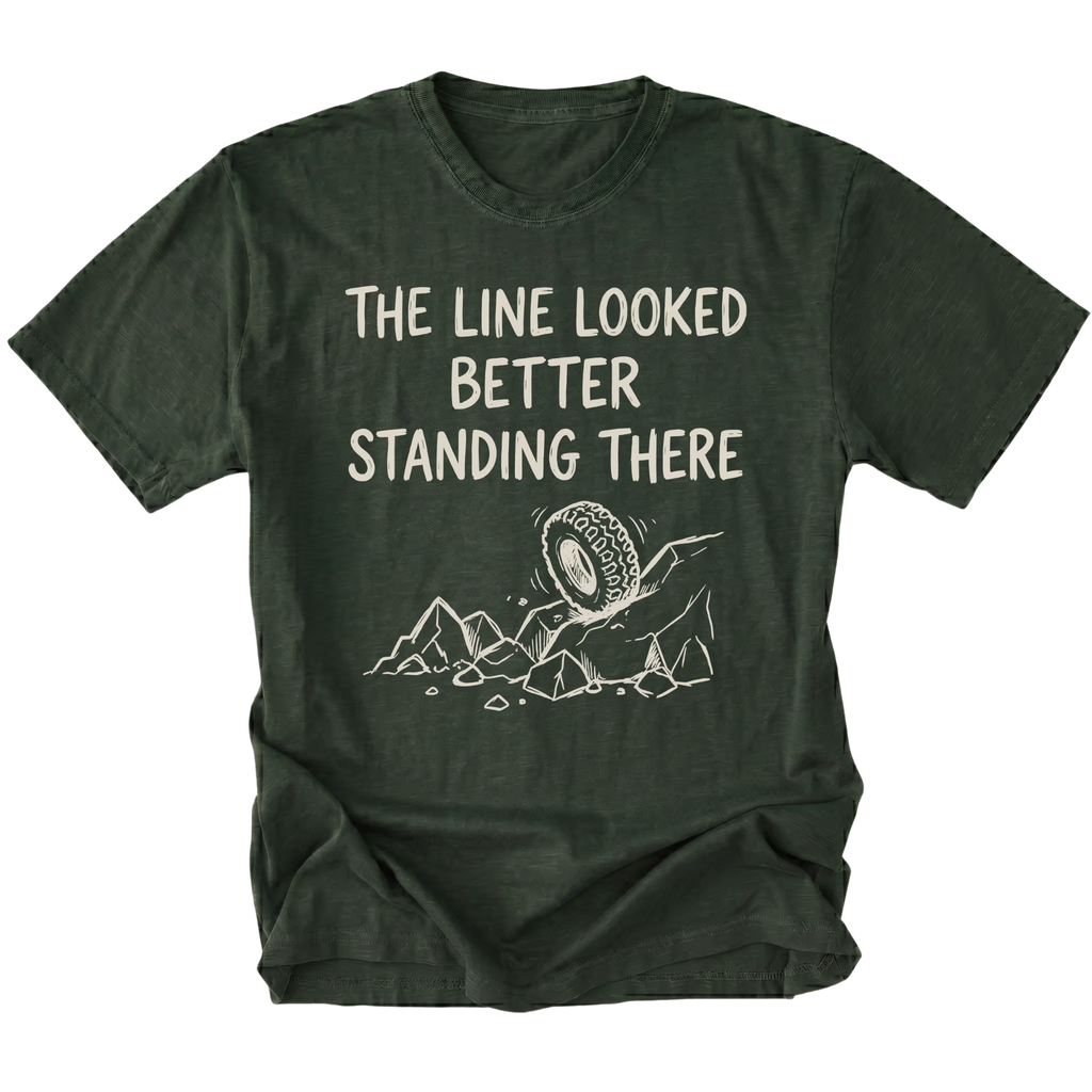 Moss T-Shirt with hand-drawn tire and rocks graphic and text reading “The Line Looked Better Standing There” shown on front view by Trail Snark.