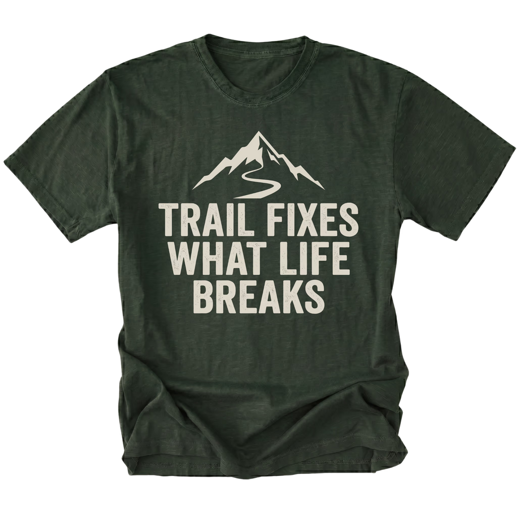 Moss t-shirt with the phrase “Trail Fixes What Life Breaks” beneath a mountain and winding trail graphic printed on the front.