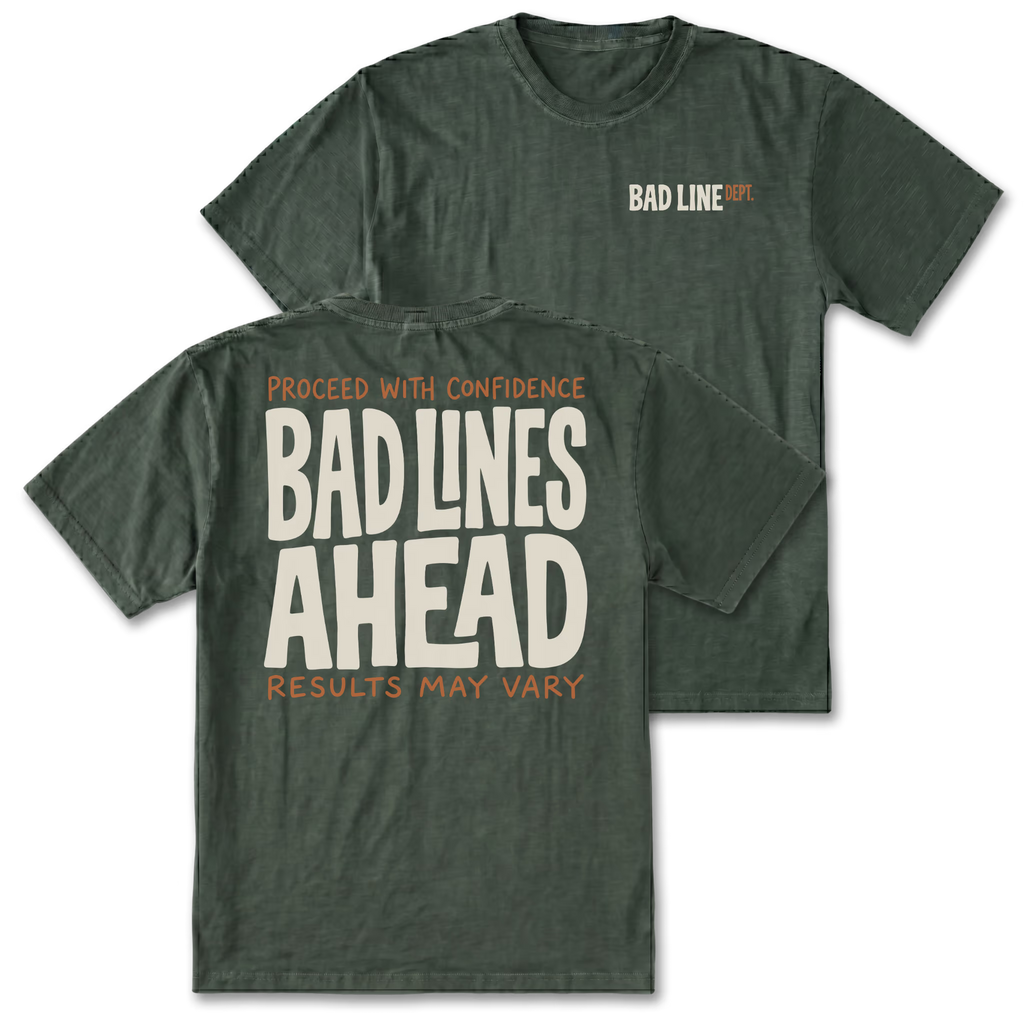 Two military green graphic t-shirts shown on a plain white background, with the front and back views overlapping. The front has a small 'BAD LINE' logo on the left chest, and the back features a large cream-colored text graphic reading 'BAD LINES AHEAD' with smaller orange text above and below.