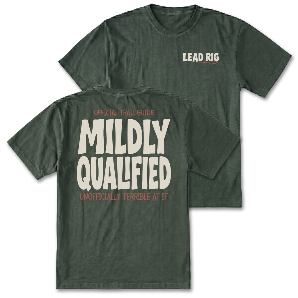 Two military green graphic t-shirts shown on a plain white background, with one displaying the front chest print 'LEAD RIG' and the other showing the back with large cream text reading 'MILDLY QUALIFIED' and smaller orange text above and below.