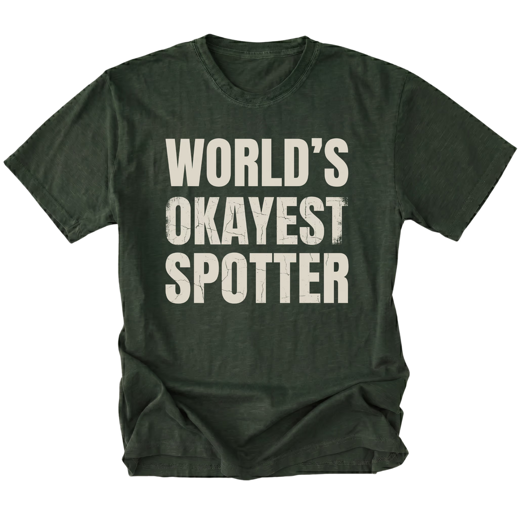 Moss t-shirt with bold distressed text reading “World’s Okayest Spotter.”