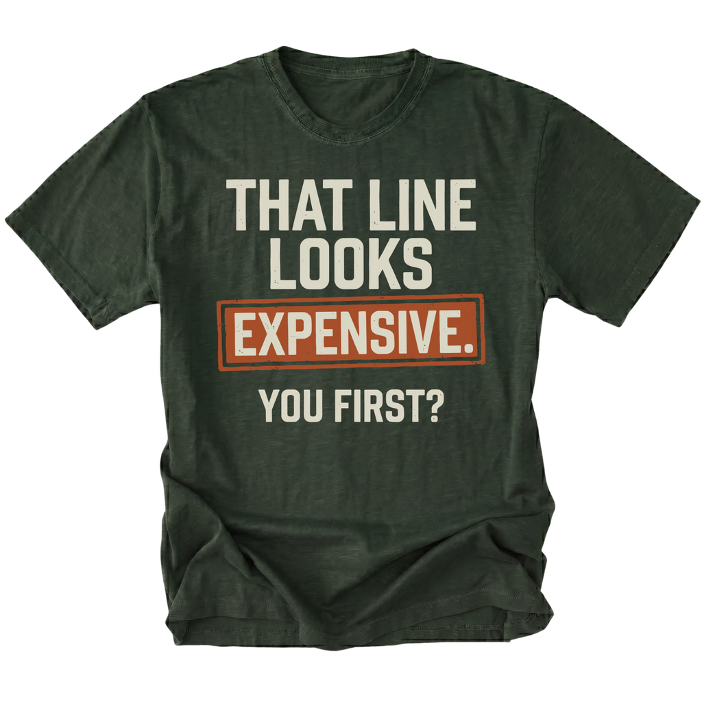 A moss green graphic t-shirt with the text 'THAT LINE LOOKS EXPENSIVE. YOU FIRST?' printed on the front.