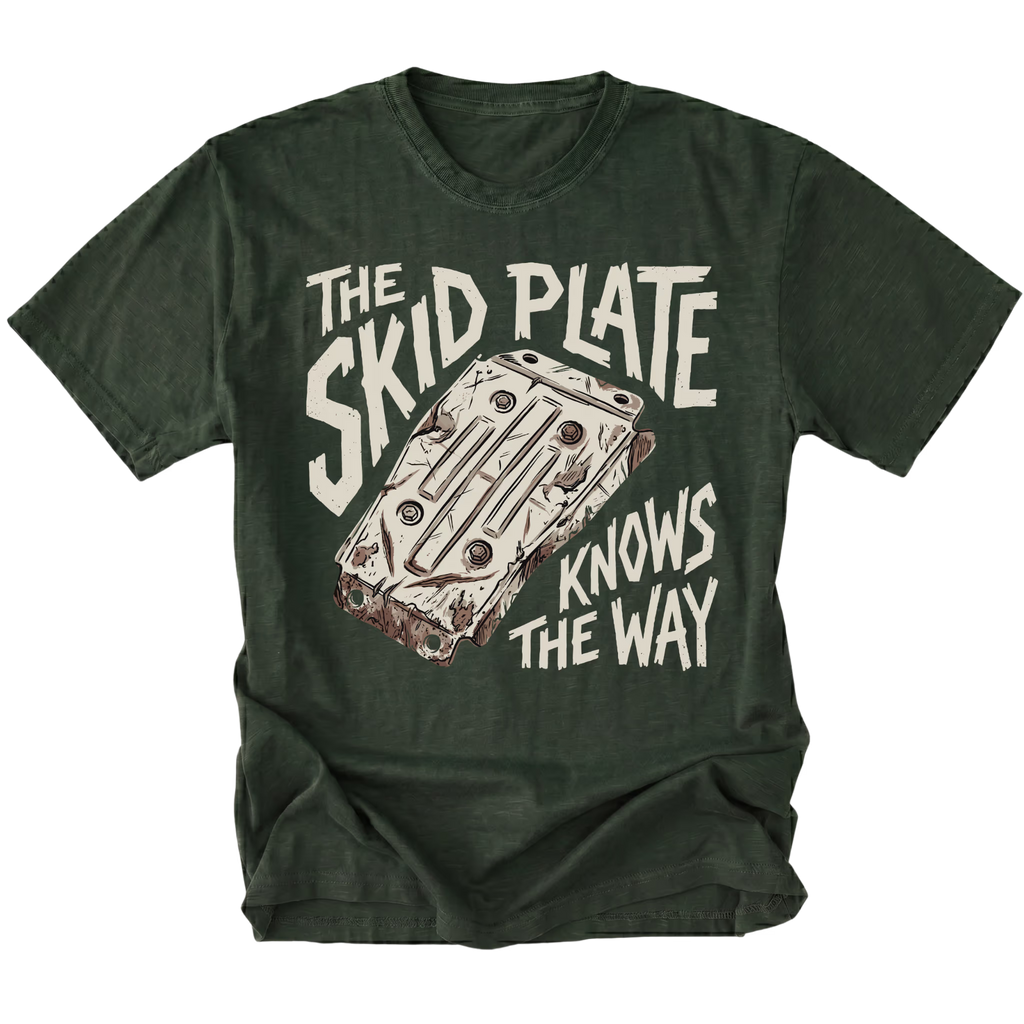 A moss green t-shirt featuring a graphic print of a car engine block with the text 'THE SKID PLATE KNOWS THE WAY' in a distressed off-white font.
