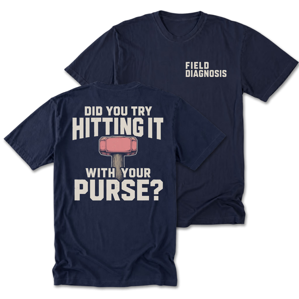 Two navy blue t-shirts shown on a plain white background, with the front and back views overlapping. The back shirt features large white text reading 'DID YOU TRY HITTING IT WITH YOUR PURSE?' and a pink-and-gray hammer graphic.