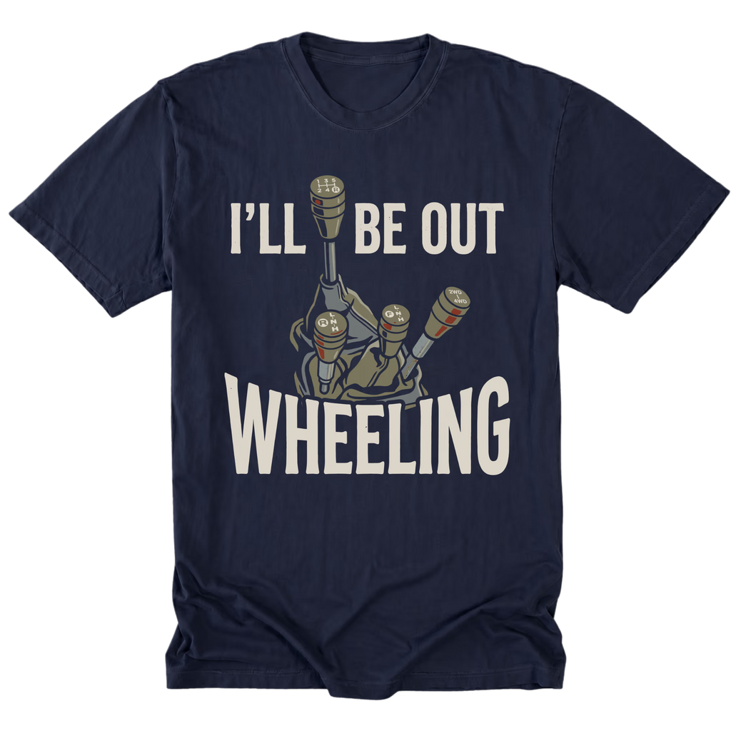 A navy blue short-sleeve t-shirt with a graphic of three manual gear shifters and the text 'I'LL BE OUT WHEELING' in a bold white font, displayed on a solid white background.