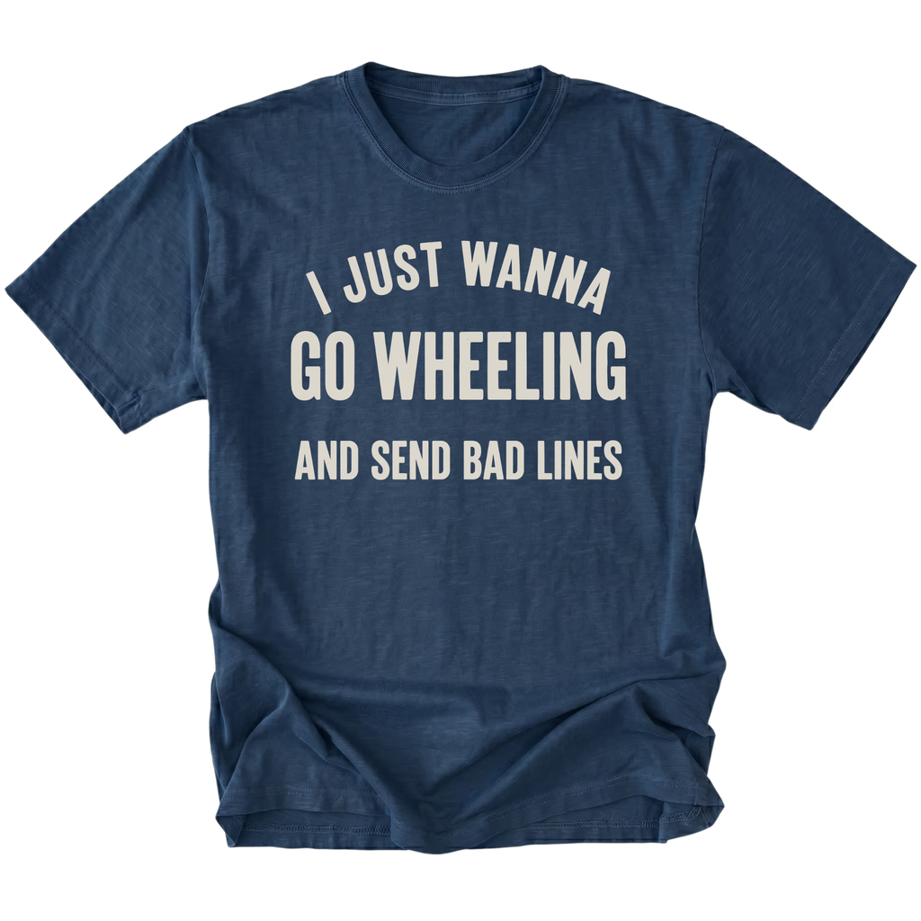 A navy blue short-sleeve t-shirt with a distressed cream-colored graphic text that reads 'I JUST WANNA GO WHEELING AND SEND BAD LINES' on a solid white background.