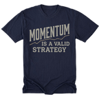 A navy blue short-sleeve t-shirt with a graphic print on the front that reads 'MOMENTUM IS A VALID STRATEGY' in a distressed beige font, displayed on a clean white background.