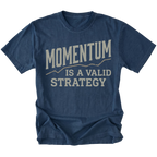 A navy blue short-sleeve t-shirt with a distressed cream-colored graphic print that reads 'MOMENTUM IS A VALID STRATEGY' on the front, displayed against a solid white background.