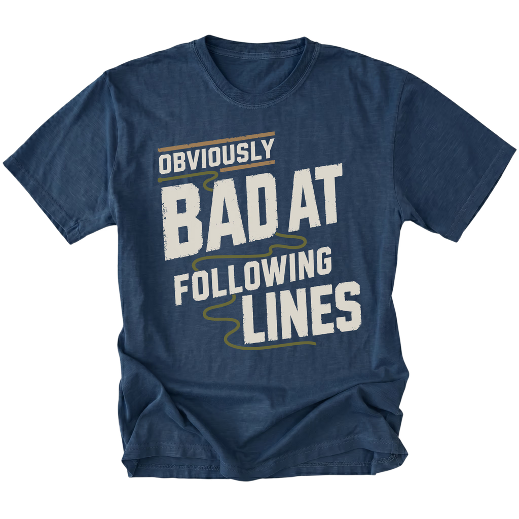 A navy blue short-sleeve t-shirt with a distressed graphic print that reads 'OBVIOUSLY BAD AT FOLLOWING LINES' in white and olive green text, shown on a plain white background.