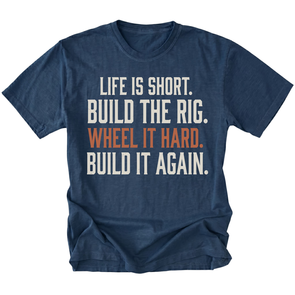 A navy blue short-sleeve t-shirt with a distressed white and orange text graphic on the front reading 'LIFE IS SHORT. BUILD THE RIG. WHEEL IT HARD. BUILD IT AGAIN.'