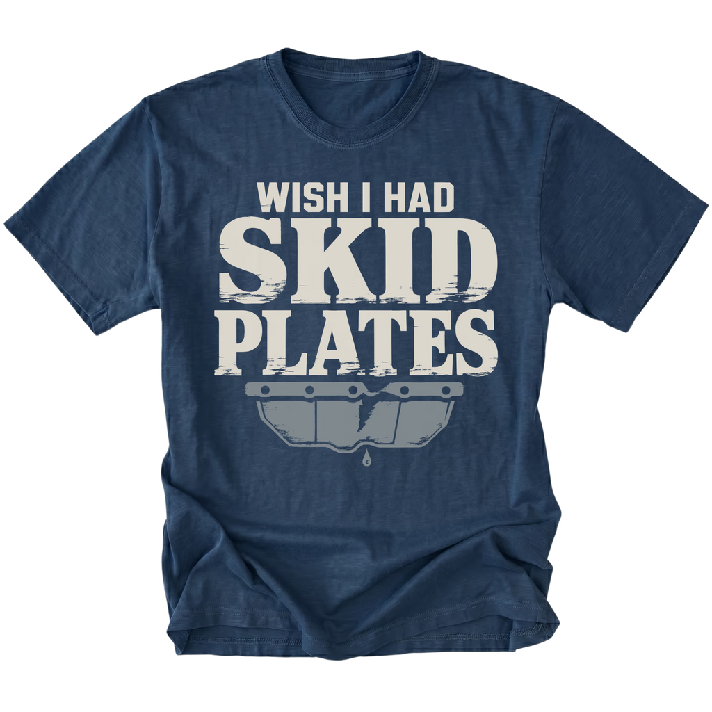 A navy blue short-sleeve t-shirt with a distressed white and gray graphic on the front that reads 'WISH I HAD SKID PLATES' above a stylized car bumper graphic, shown on a plain white background.