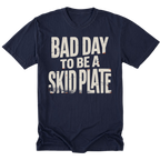 A navy blue tall short-sleeve t-shirt with a distressed white graphic text reading 'BAD DAY TO BE A SKID PLATE' on the front, displayed against a solid white background.