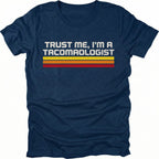 Navy t-shirt with retro stripes and the phrase “Trust Me, I’m a Tacomaologist” printed on the front by Trail Snark.
