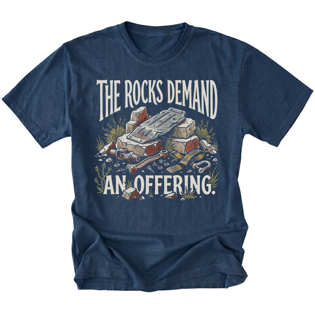 A navy blue short-sleeve t-shirt with a graphic print on the front. The graphic features the text 'THE ROCKS DEMAND AN OFFERING.